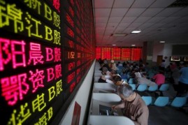 Investors look at computer screens showing stock information at a brokerage house in Shanghai, May 26, 2015.