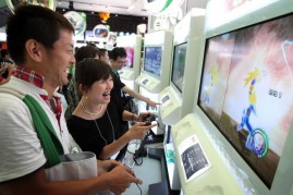 Visitors play Namco Bandai Games Inc.'s 'Dragon Ball Raging Blast 2' on Microsoft Corp.'s Xbox 360 video game consoles during the Tokyo Game Show 2010 at Makuhari Messe on September 16, 2010 in Chiba, Japan.