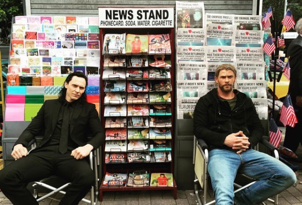 Today in Brisbane, Chris Hemsworth (God of Thunder) and Tom Hiddleston (God of Mischief) are sitting in front of a newsstand which has intriguing newspapers headlines.